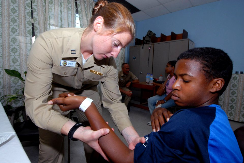 US Navy 070917-N-8704K-072 Lt. Gwen Smith, attached to Military Sealift Command hospital ship USNS Comfort (T-AH 20), performs physical therapy for Marcus Pryce at the Arima Health Facility