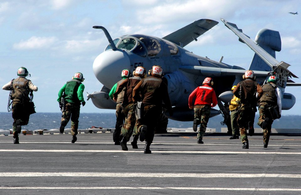 US Navy 070917-N-8923M-054 Sailors assigned to the Zappers of Tactical Electronic Warfare Squadron (VAQ) 130 hurry across the landing area on the flight deck during flight operations aboard Nimitz-class aircraft carrier USS Har