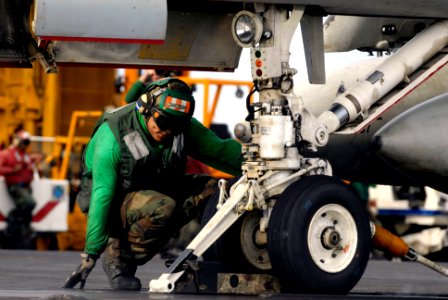 US Navy 070910-N-7883G-009 Airman Luis Estrada, topside petty officer for the waist catapult aboard USS Kitty Hawk (CV 63), verifies that the holdback bar is in place prior to launch