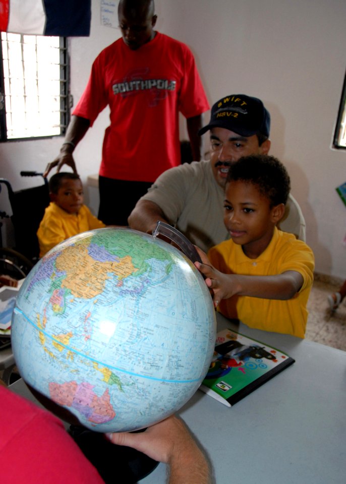 US Navy 070912-N-9486C-001 Chief Warrant Officer Dan Trevino, chief engineer aboard High Speed Vessel (HSV 2) Swift, shows one of the children at Jackie's House Orphanage where he's from photo