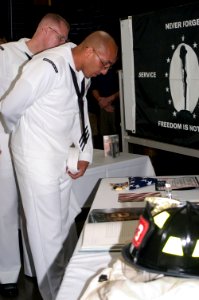 US Navy 070911-N-9520G-001 During a memorial ceremony, Personnel Specialist 1st Class Louis Saldana looks at displays representing those who have lost their lives while serving their country