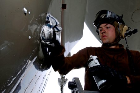 US Navy 070912-N-7883G-025 Aviation Machinist's Mate Airman Jeromy Coleman wipes a wing of an E-2C Hawkeye, attached to the Liberty Bells of Carrier Airborne Early Warning Squadron (VAW) 115, aboard USS Kitty Hawk (CV 63)