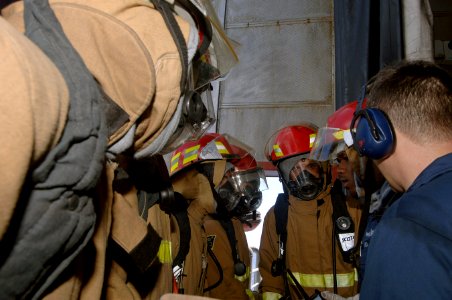 US Navy 070915-N-0989H-012 Mineman 1st Class Courtney Haralson, assigned to the High Speed Vessel (HSV 2) Swift, briefs members of the number one hose team before entering the port engine room during a fire drill