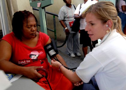 US Navy 070919-N-6278K-106 Laura Seris, a registered nurse and Project Hope volunteer attached to Military Sealift Command hospital ship USNS Comfort (T-AH 20), takes a blood pressure reading from a patient photo