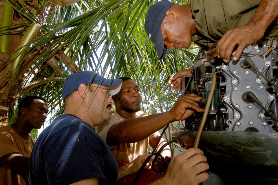 US Navy 070920-N-0989H-052 Machinery Technician 1st Class Joseph Hernandez, assigned to the U.S. Coast Guard International Training Division, assists members of the Jamaica Defense Force Coast Guard with troubleshooting a Yamah