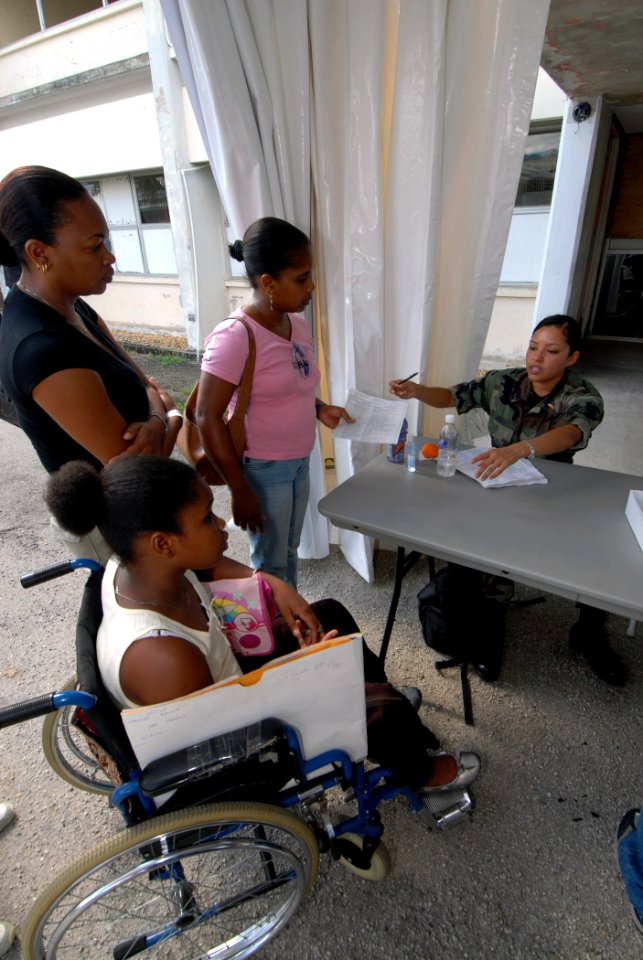 US Navy 070917-N-8704K-039 Senior Airman Angie Rincon, attached to Military Sealift Command hospital ship USNS Comfort (T-AH 20), checks in patients at the Arima Health Facility