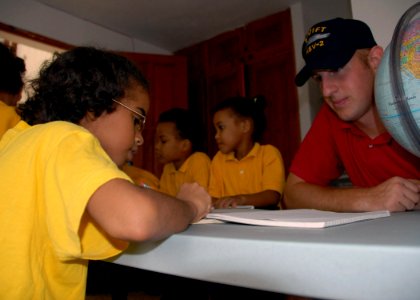 US Navy 070912-N-9486C-004 Gunner's Mate 2nd Class Justin Webb helps a girl with her schoolwork at Jackie's House Orphanage during a community relations project