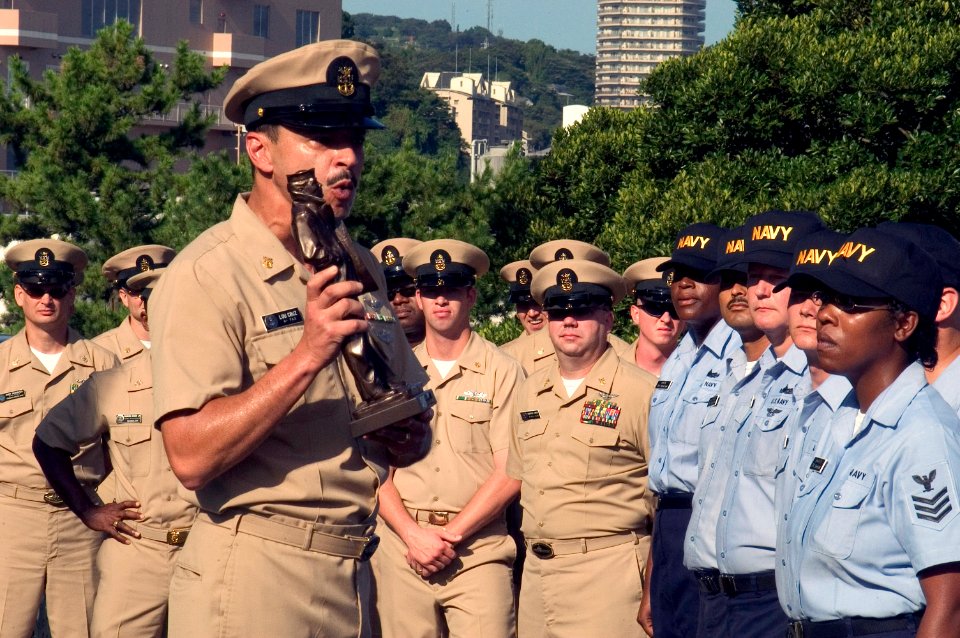 US Navy 070920-N-9520G-003 Command Master Chief Luis Cruz holds a statue of the Lone Sailor as he speaks to chief petty officer selectees about their new leadership role