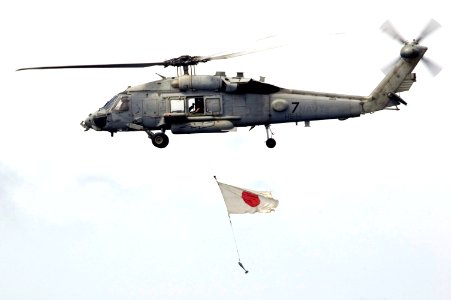US Navy 070917-N-5387K-052 An SH-60 Seahawk, attached to the Chargers of Helicopter Anti-Submarine Squadron (HS) 14, flies past USS Kitty Hawk (CV 63) with a Japanese flag during a practice air show
