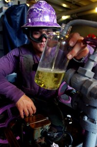 US Navy 070918-N-5148B-055 Aviation Boatswain's Mate (Fuel) 3rd Class Bryan Oliveria takes a JP-5 fuel sample aboard nuclear-powered aircraft carrier USS Nimitz (CVN 68) during a replenishment at sea