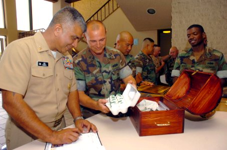 US Navy 070917-N-0775Y-065 Equipment Operator 1st Class Emory Cole shows Master Chief Petty Officer of the Navy (MCPON) Joe R. Campa Jr. a box of eggs representing the troops he's about to lead photo