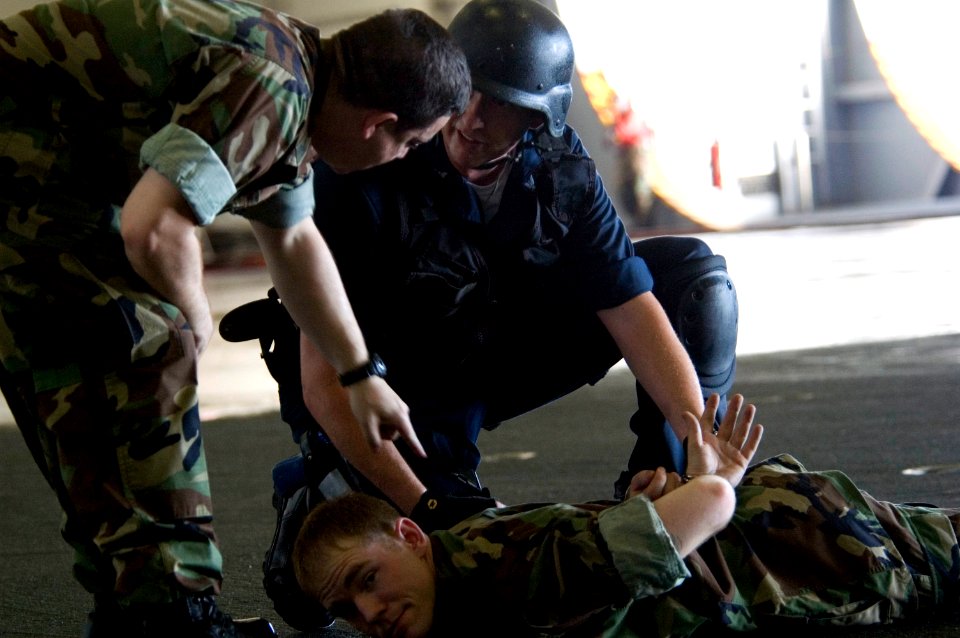 US Navy 070919-N-5387K-035 Anti-terrorism instructor Aviation Ordnanceman 1st Class Michael Ciaverelli instructs shipboard reaction force trainees during a tactical force protection drill in the hangar bay aboard USS Kitty Hawk