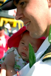 US Navy 070922-N-0879R-009 An officer greets his baby daughter after returning on guided missile destroyer USS Chafee (DDG 90) from a deployment