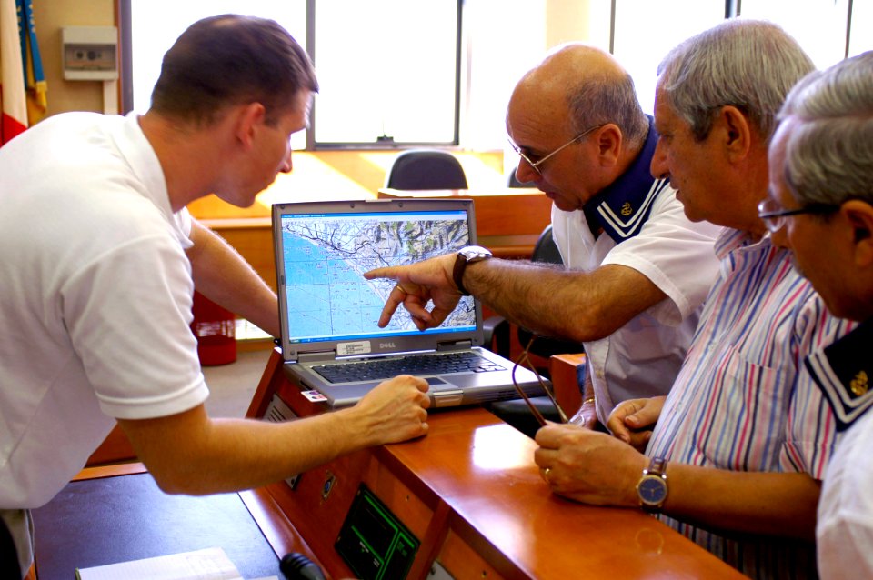 US Navy 070920-N-5821P-002 Gunnery Sgt. Jason Heyman, Joint P.O.W.-M.I.A Accounting Command (JPAC) assistant team leader, reviews a map with village elders to determine the whereabouts of possible sites for excavation