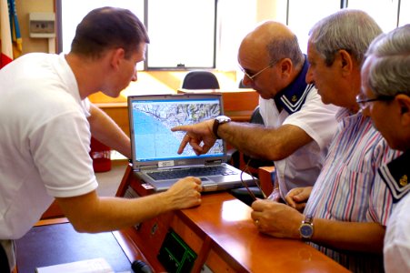 US Navy 070920-N-5821P-002 Gunnery Sgt. Jason Heyman, Joint P.O.W.-M.I.A Accounting Command (JPAC) assistant team leader, reviews a map with village elders to determine the whereabouts of possible sites for excavation