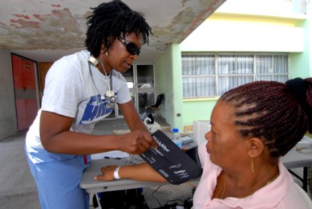 US Navy 070917-N-8704K-033 Project Hope volunteer Joy Williams, attached to Military Sealift Command hospital ship USNS Comfort (T-AH 20), checks the vital signs of a patient at the Arima Health Facility photo
