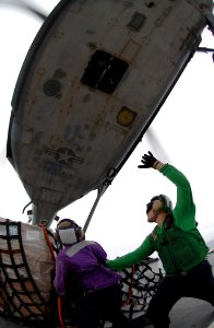 US Navy 070923-N-0194K-050 Aviation Boatswain's Mate (Fuel) 3rd Class Alicia Garcia, left, and Aviation Structural Mechanic 2nd Class Kolt McGuin secure cargo to an MH-60S Seahawk