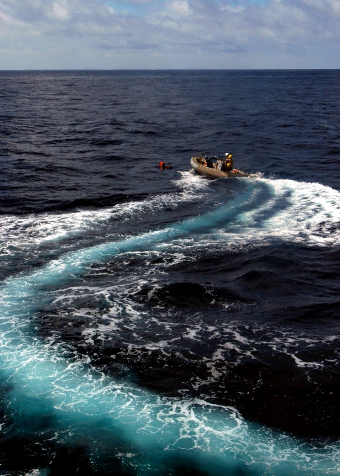 US Navy 070920-N-4014G-055 A rigid hull inflatable boat from guided-missile destroyer USS Porter (DDG 78) maneuvers to pick up a floating dummy simulating an overboard crew member during a man overboard drill