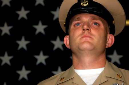 US Navy 070921-N-1831S-065 Newly pinned Chief Boatswain's Mate Jason Kinsey stands at attention during the chief pinning ceremony aboard amphibious assault ship USS Kearsarge (LHD 3)
