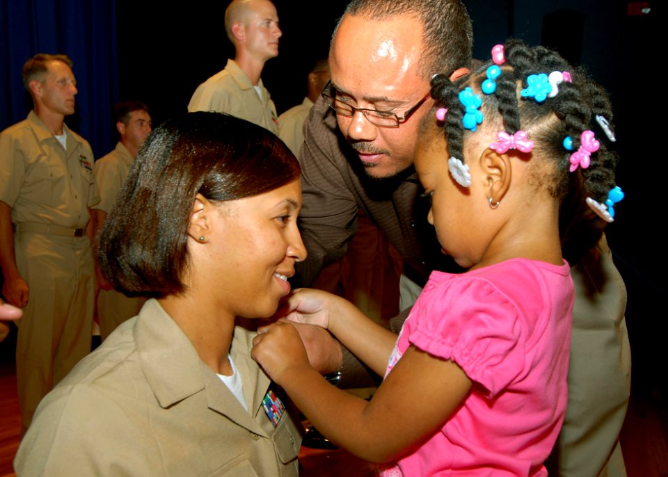 US Navy 070921-N-8544C-112 Chief Master-at-Arms Malika Derios of Precommissioning Unit (PCU) George H. W. Bush (CVN 77) receives her anchors from her daughter and stepfather during the chief's pinning ceremony at Langley