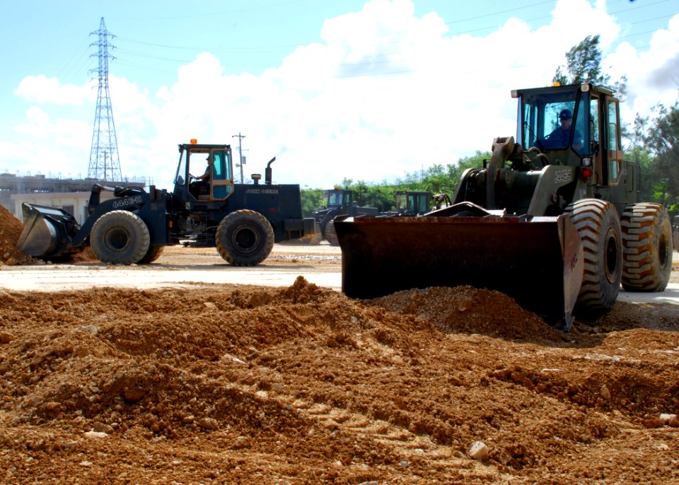 US Navy 070925-N-1120L-052 Equipment Operator 2nd Class Gerald Flint uses a front end loader to fill a crater in a simulated runway on Kadena Air Base as part of a joint-training exercise with the Air Force