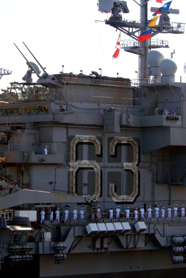 US Navy 070921-N-4790M-313 Sailors stationed aboard USS Kitty Hawk (CV 63) man the rails as the ship pulls into her homeport following a four-month summer deployment