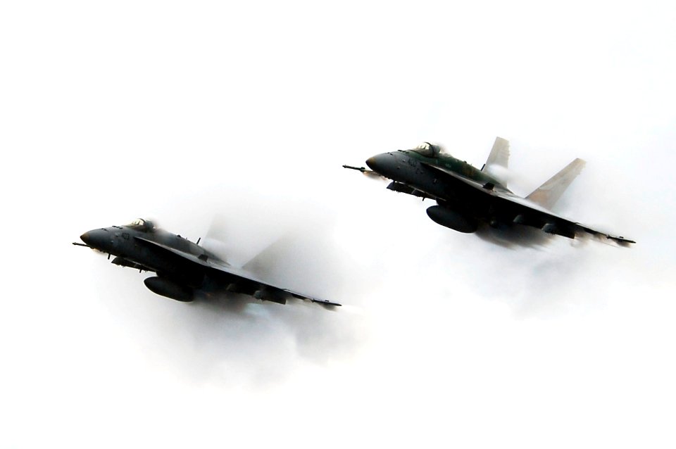 US Navy 070923-N-3136P-039 Two F-A-18C Hornets punch through a cloud of water vapor while breaking the sound barrier