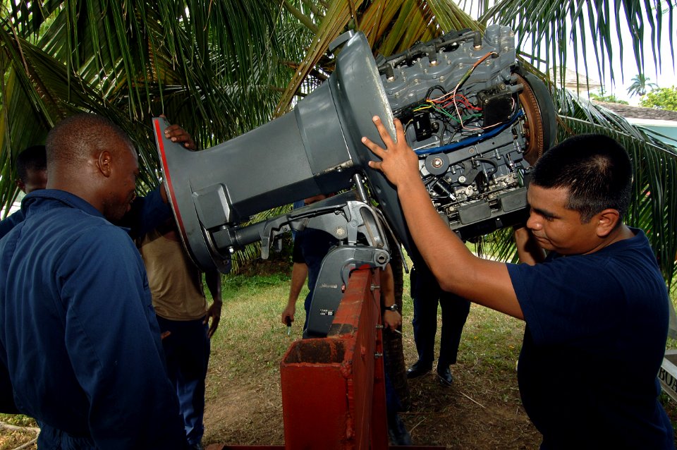 US Navy 070926-N-0989H-014 Machinery Technician 2nd Class Javier Carpio, from the U.S. Coast Guard International Training Division, assists members of the Jamaica Defense Force with troubleshooting an engine