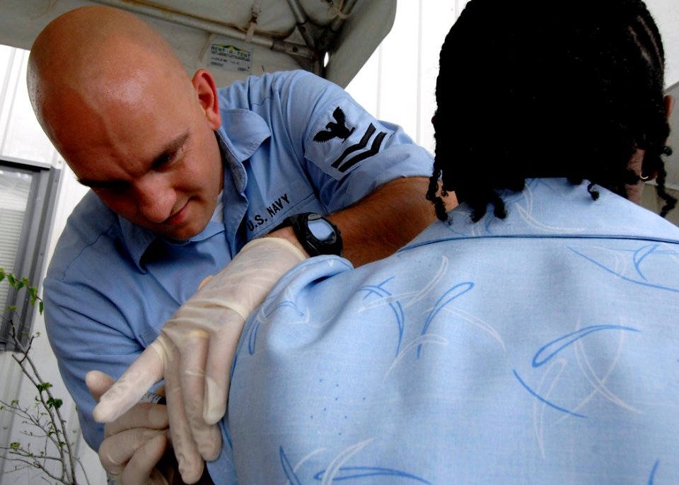 US Navy 070926-N-6278K-007 Hospital Corpsman 2nd Class Chad Galvin, a respiratory therapy technician attached to Military Sealift Command hospital ship USNS Comfort (T-AH 20), gives an immunization shot to a patient