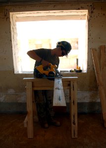US Navy 070922-N-3560G-017 Construction Electrician Constructionman Jennifer McGhee, attached to Naval Mobile Construction Battalion (NMCB) 4, cuts window framing during the conversion of an old Iraqi prison