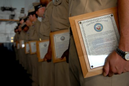 US Navy 070921-N-6854D-003 Chief petty officers hold on to a plaque scribed with the Chief Petty Officer's Creed during their pinning ceremony