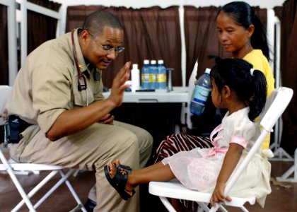 US Navy 070925-N-0194K-087 U.S. Public Health Service Lt. Cmdr. Jamal Gwathney, a family medicine physician attached to Military Sealift Command hospital ship USNS Comfort (T-AH 20), speaks with 3-year-old girl and her mother a photo