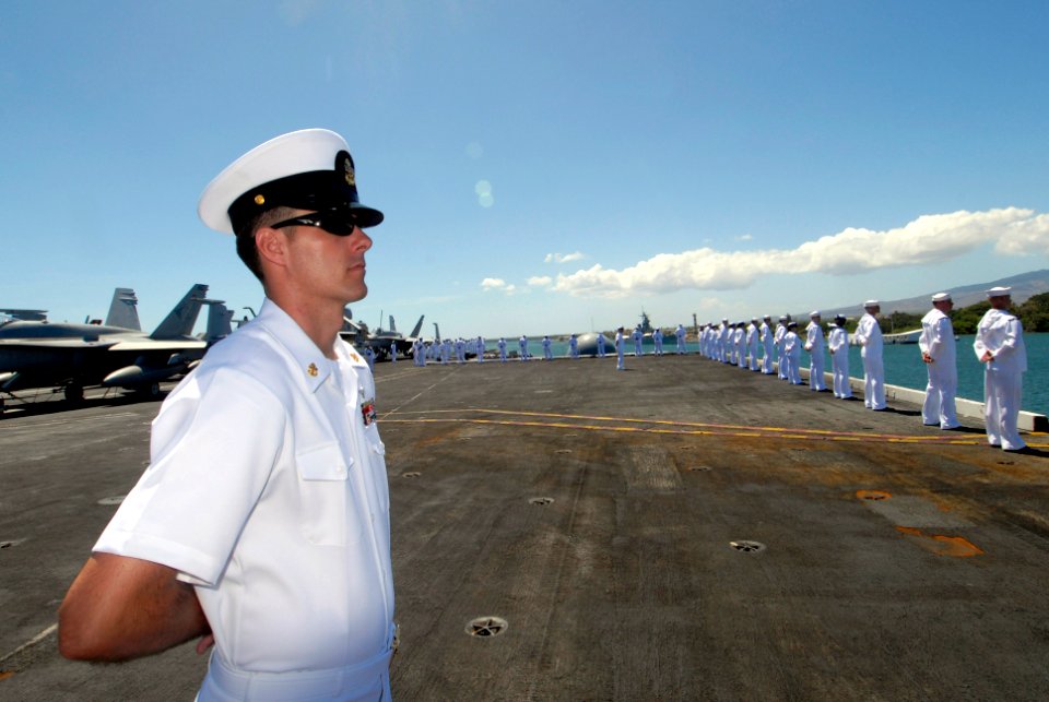 US Navy 070922-N-6326B-127 Chief Aviation Structural Mechanic Scott Lane stands at parade rest on the flight deck as Sailors man the rails