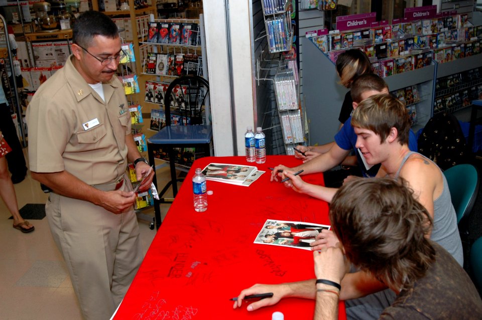 US Navy 070925-N-2456S-045 Chief Aviation Electronics Technician Eraclio Sanchez, assigned to Helicopter Sea Combat Wing Atlantic, gets an autographed photo of the band All Time Low at the Naval Station Norfolk Navy Exchange