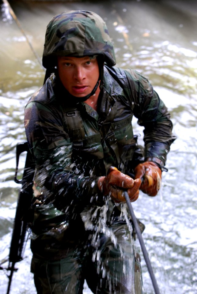 US Navy 070927-N-4267W-284 Steelworker 3rd Class Doug Horox, with Naval Mobile Construction Battalion (NMCB) 7, low crawls through a stream during a jungle warfare training evolution hosted by Marines with the Jungle Warfare Tr