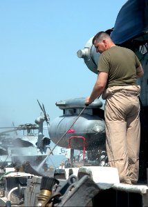 US Navy 070926-N-1226D-026 Staff Sgt. Sidney Bushnel, a native of Dry Creek, La., uses a power washer to remove dirt from a CH-53 Sea Knight in preparation for an agriculture inspection aboard USS Bonhomme Richard (LHD 6)