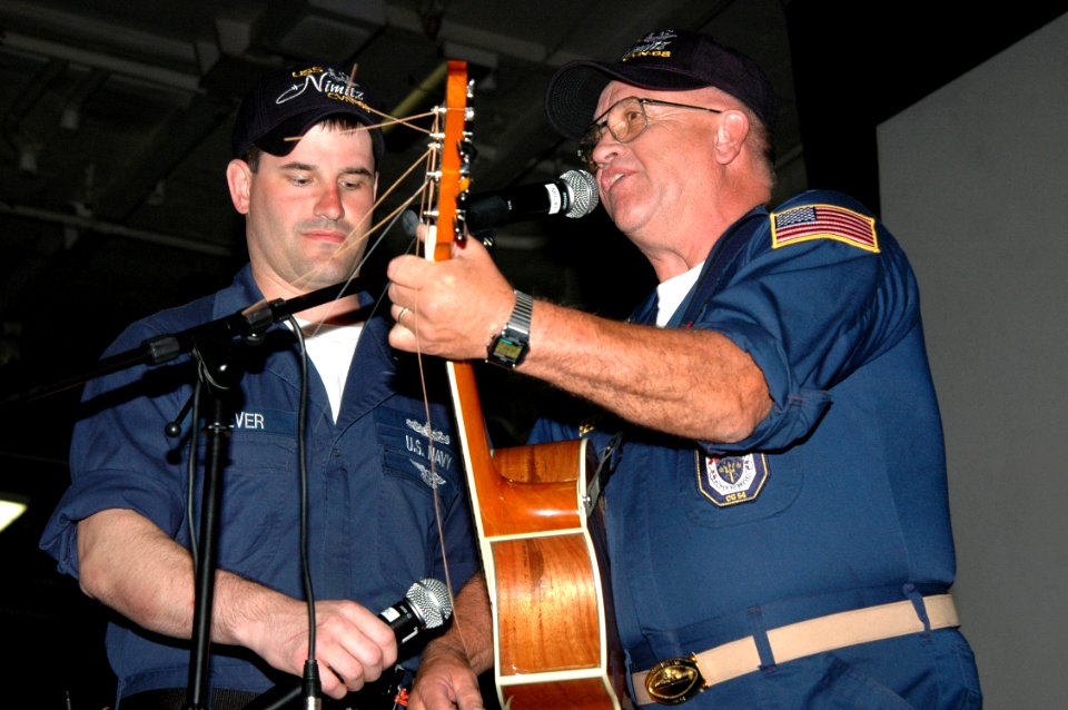 US Navy 070925-N-7128A-080 Larry Seever, a retired Navy chief, performs a song with some help from his son, Electronics Technician 2nd Class Shawn Seever, during the Tiger Cruise Talent Show