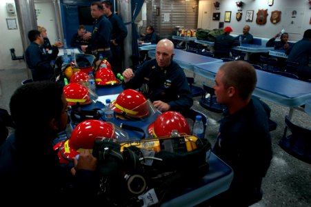US Navy 070928-N-4014G-196 Command Master Chief Dominick Musso speaks with Information Systems Technician Seaman Dennis Figueroa and Seaman Justin Martin about various firefighting techniques aboard guided-missile destroyer USS