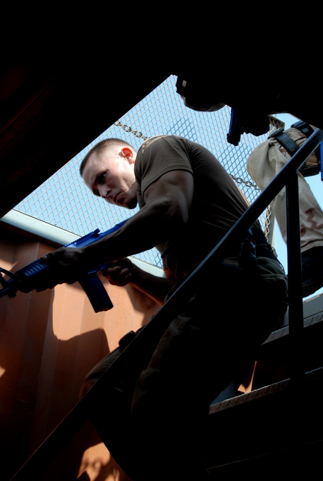 US Navy 070926-N-5307M-003 Damage Controlman Fireman James Ebert enters a compartment space as part of a visit, board, search, and seizure (VBSS) training scenario