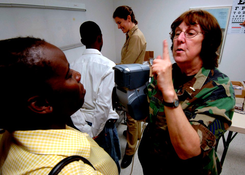US Navy 070926-N-6278K-061 Air Force Tech. Sgt. Cynthia Sanders, an optometry technician attached to Military Sealift Command hospital ship USNS Comfort (T-AH 20), examines a patient's eyes at the Project Dawn at Lilienda
