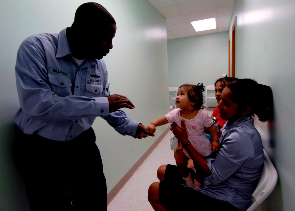 US Navy 070926-N-6278K-057 Yeoman 3rd Class Keith Williamsbey, attached to Military Sealift Command hospital ship USNS Comfort (T-AH 20), waves hello to seven-month-old girl