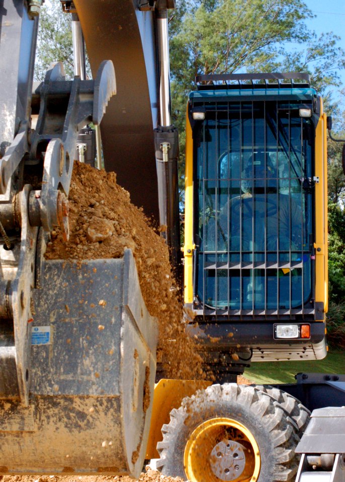 US Navy 070925-N-1120L-005 Equipment Operator 1st Class Van Johnson begins excavating a crater in a simulated runway on Kadena Air Base as part of a joint-training exercise with the Air Force