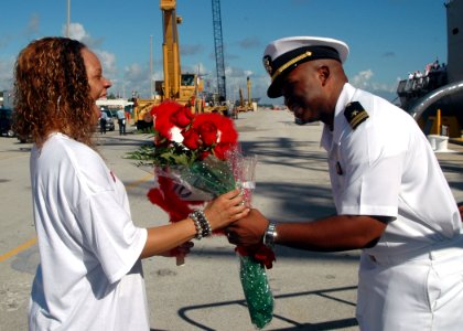 US Navy 070926-N-1522S-007 Lt. Jaiwan Mack presents his wife with flowers before the traditional first kiss at the homecoming of guided-missile frigate USS Samuel B. Roberts (FFG 58)