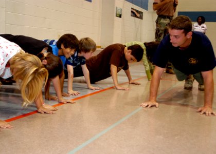US Navy 071002-N-5208T-003 Students at Heritage Elementary receive instruction on proper push-up technique from members of Special Boat Unit, Team 12, from San Diego photo
