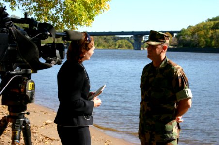 US Navy 071003-N-7163S-001 Cmdr. Dan Shultz, commanding officer of Mobile Diving and Salvage Unit (MDSU) 2, interviews with KSTP-TV reporter Colleen Mahoney along the banks of the Mississippi River near downtown Minneapolis