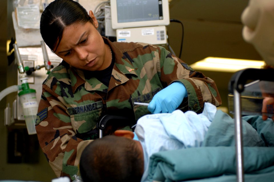 US Navy 071003-N-7088A-011 U.S. National Guard Senior Airman Belitza Hernandez, attached to the post anesthesia care unit aboard Military Sealift Command hospital ship USNS Comfort (T-AH 20), helps a recovering patient after su