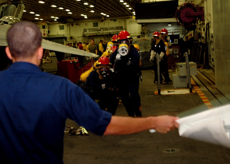 US Navy 070928-N-1226D-002 Boatswain's Mate 2nd Class Luis Adames, a native of Jersey City, N.J., simulates a class alpha fire in the hangar bay