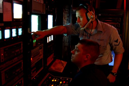 US Navy 071001-N-7571S-001 Mass Communication Specialist 3rd Class Nathan Lockwood, from Kenmore, Wash., directs Mass Communication Specialist 2nd Class Erik Siegel, from Elmira, N.Y., on the shipboard information, television a