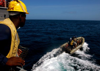 US Navy 071006-N-4014G-019 Boatswain's Mate 2nd Class Anthony Henderson watches as a rigid hull inflatable boat departs guided-missile destroyer USS Porter (DDG 78) loaded with members of Porter's visit, board, search and seizu