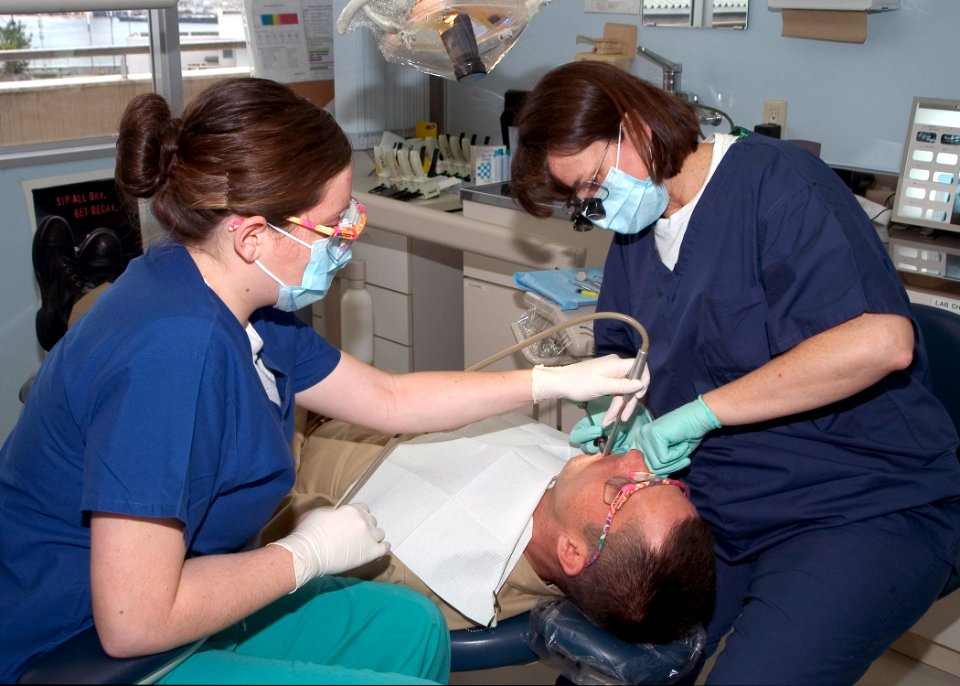 US Navy 071031-N-0483B-001 Lt. Cmdr. Martha Michaelson and Hospitalman Tiffany Ciampo, both assigned to U.S. Naval Hospital Yokosuka Fleet Dental Clinic, provide dental care to a Sailor